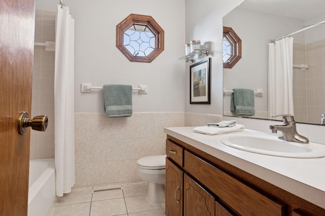 full bath featuring visible vents, tile patterned flooring, wainscoting, tile walls, and toilet