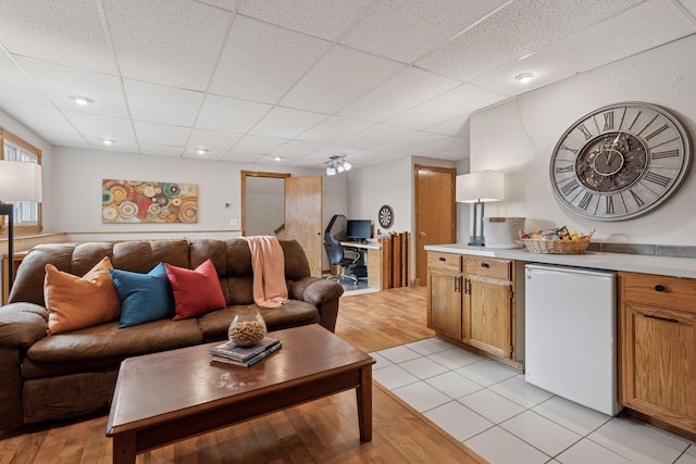 living room featuring light tile patterned flooring, a paneled ceiling, and recessed lighting