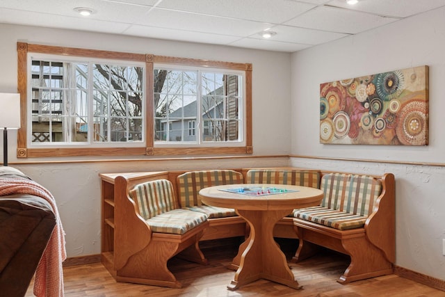 dining area featuring a drop ceiling, recessed lighting, baseboards, and wood finished floors