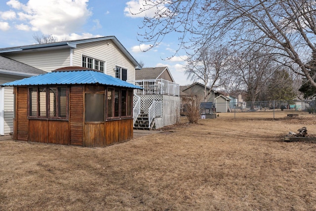 view of home's exterior with stairway, a yard, and fence