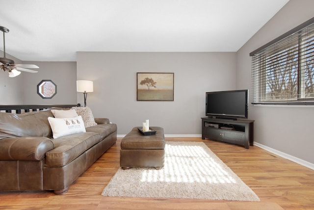 living area with vaulted ceiling, baseboards, a ceiling fan, and wood finished floors