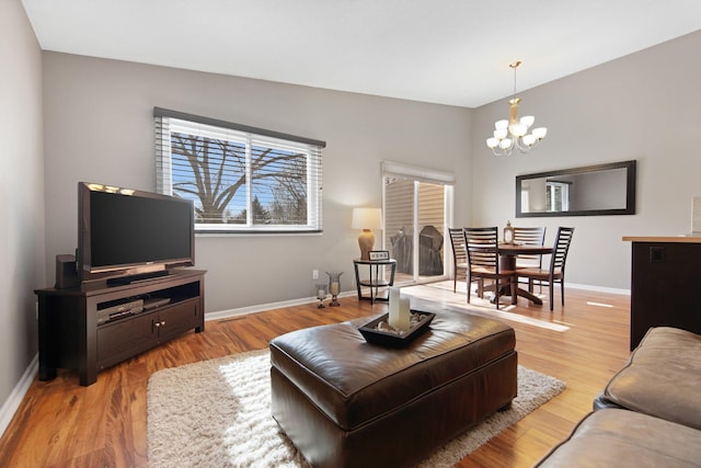 living room with baseboards, an inviting chandelier, and wood finished floors