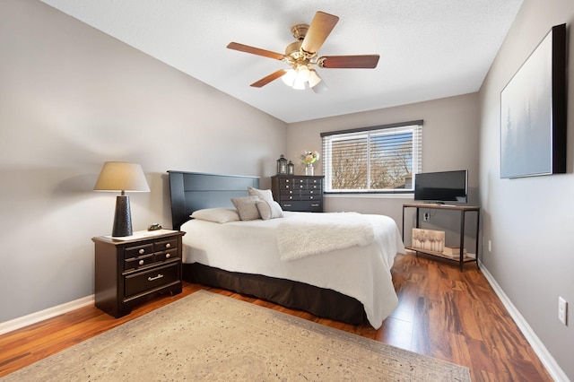 bedroom featuring vaulted ceiling, baseboards, and wood finished floors