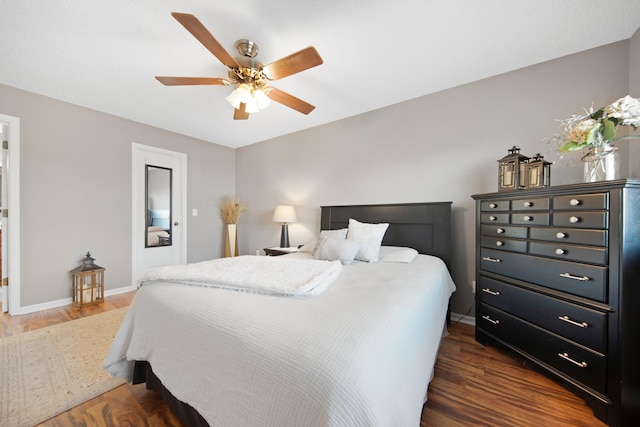 bedroom featuring dark wood finished floors, a ceiling fan, and baseboards