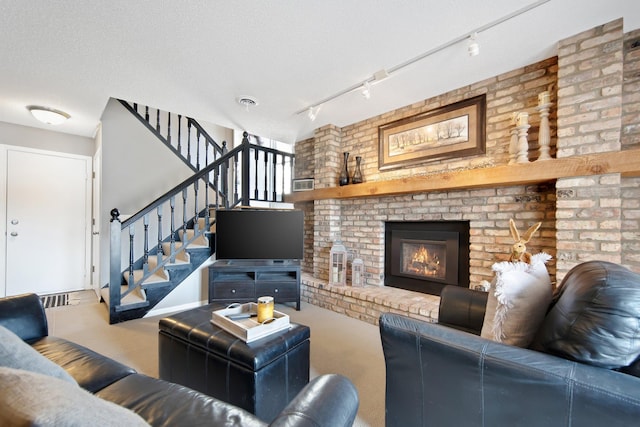 carpeted living area with stairway, a textured ceiling, a brick fireplace, and visible vents