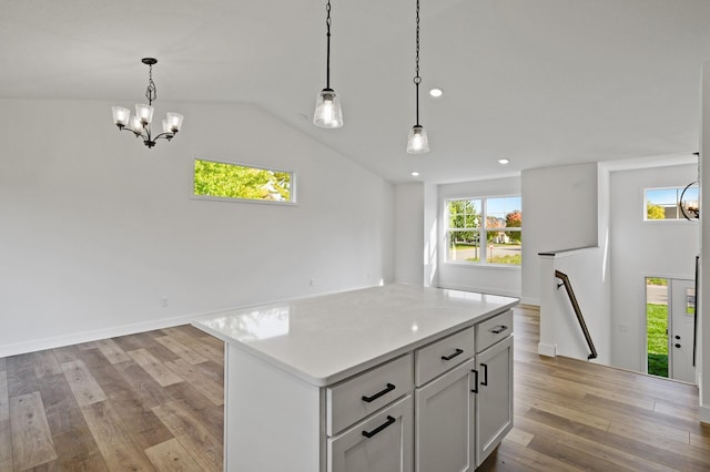 kitchen with open floor plan, a center island, light wood-type flooring, and light countertops