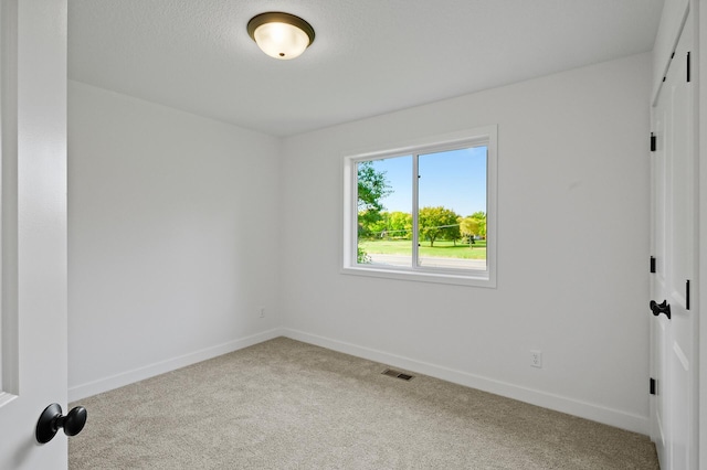 carpeted empty room with baseboards and visible vents