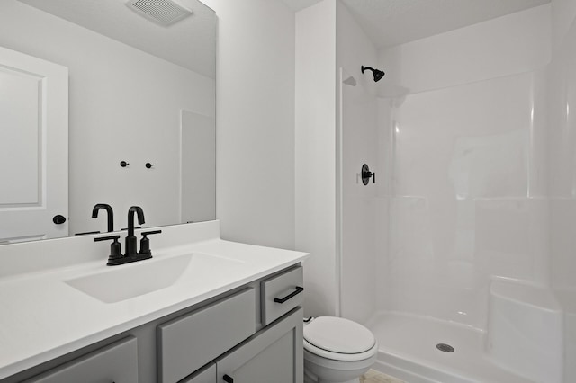 full bathroom featuring a shower, visible vents, toilet, and vanity