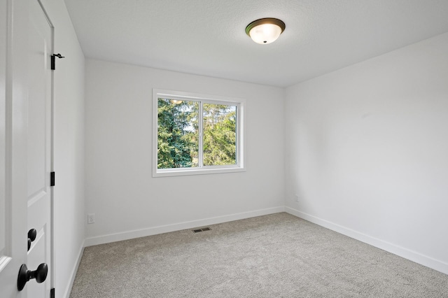 unfurnished bedroom with visible vents, a textured ceiling, baseboards, and carpet