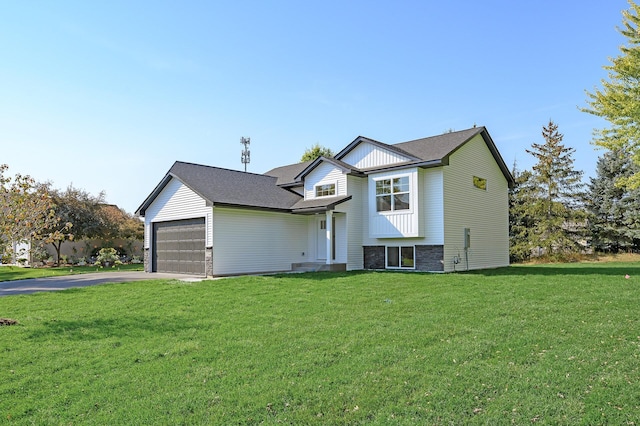 tri-level home featuring aphalt driveway, a front lawn, a garage, and roof with shingles