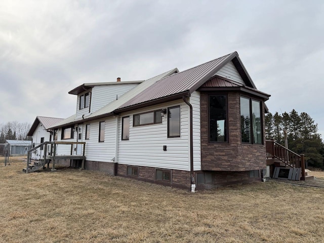 view of property exterior featuring a lawn and metal roof