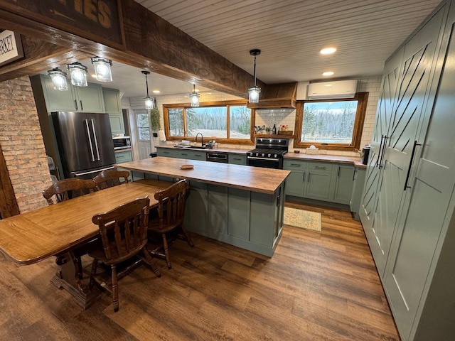 kitchen featuring a sink, green cabinets, an AC wall unit, appliances with stainless steel finishes, and dark wood-style flooring