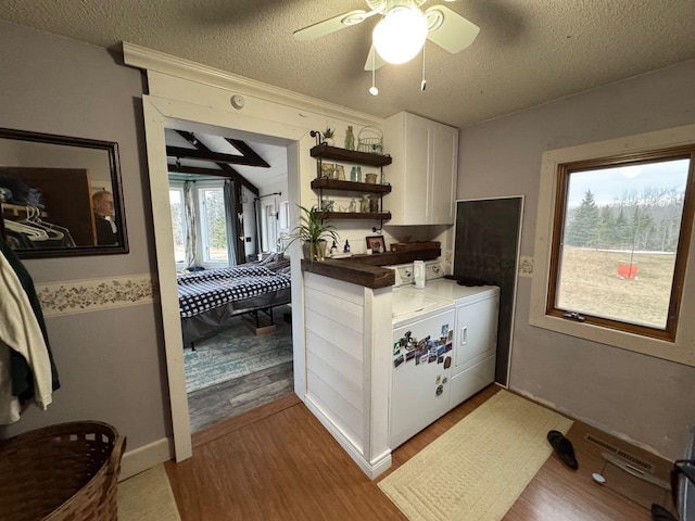 kitchen with white cabinetry, light wood-type flooring, independent washer and dryer, a textured ceiling, and open shelves