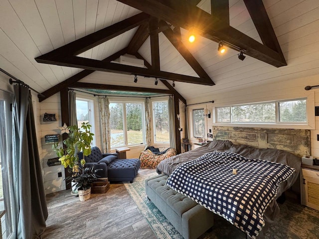 bedroom with track lighting, wood finished floors, wood walls, wood ceiling, and vaulted ceiling with beams