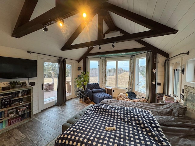 bedroom with access to exterior, multiple windows, lofted ceiling with beams, and wood finished floors