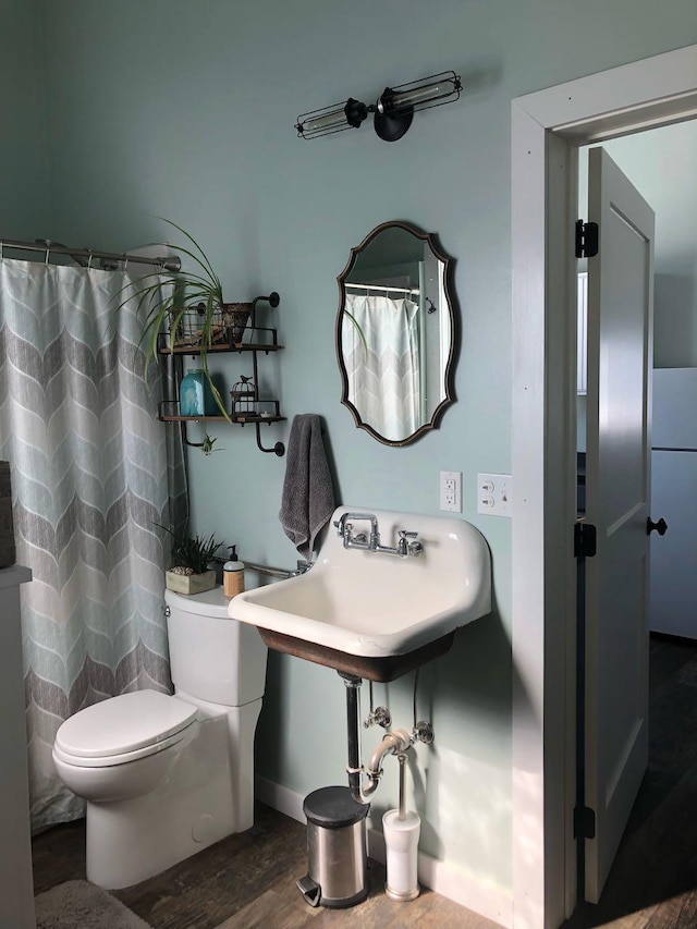 full bath with curtained shower, toilet, and wood finished floors