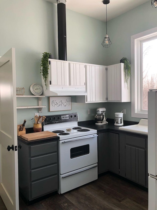 kitchen with under cabinet range hood, dark wood finished floors, decorative light fixtures, white cabinets, and white appliances