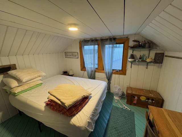 bedroom with wooden walls and vaulted ceiling