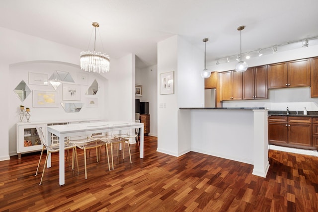 500 Grant St Unit 807, Minneapolis, MN 55404 - kitchen with dark countertops, pendant lighting, freestanding refrigerator, dark wood-style floors, and a sink
