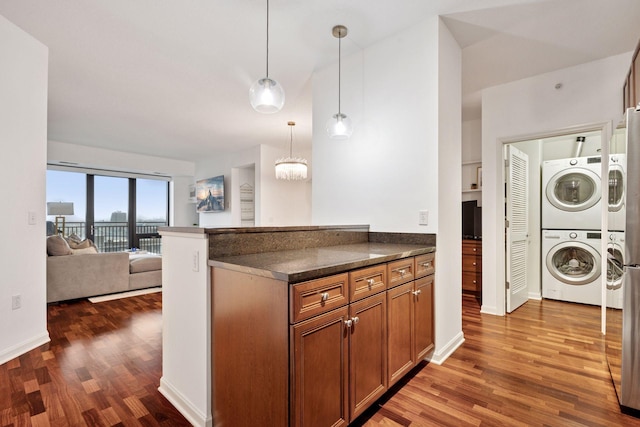 500 Grant St Unit 807, Minneapolis, MN 55404 - kitchen featuring dark countertops, wood finished floors, brown cabinetry, and stacked washer and clothes dryer