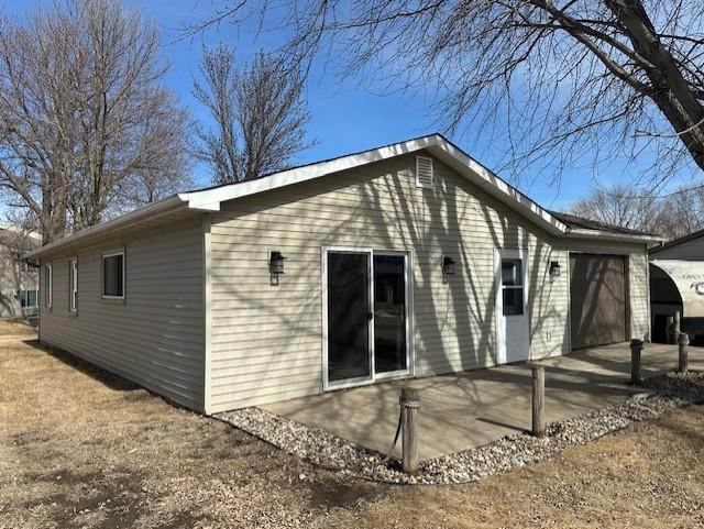 rear view of house with a garage and a patio area