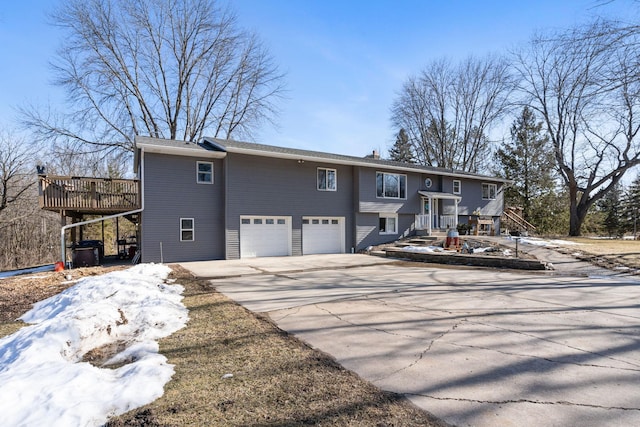 bi-level home with concrete driveway and an attached garage