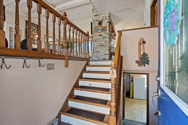 stairway with wooden ceiling, lofted ceiling, and a textured wall