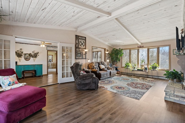 living room with a fireplace with raised hearth, wood finished floors, french doors, baseboard heating, and vaulted ceiling with beams