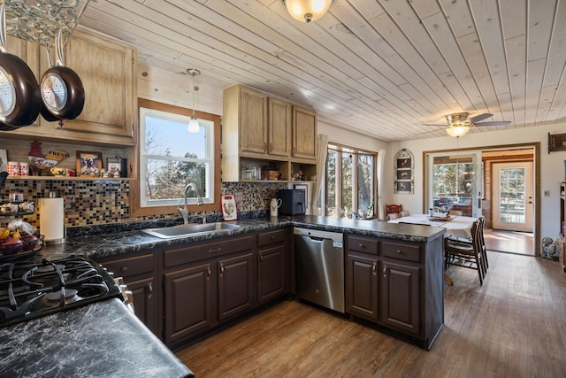 kitchen featuring a sink, open shelves, stainless steel dishwasher, dark countertops, and wood finished floors