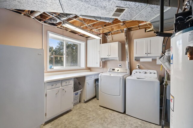 laundry room with gas water heater, visible vents, cabinet space, and separate washer and dryer