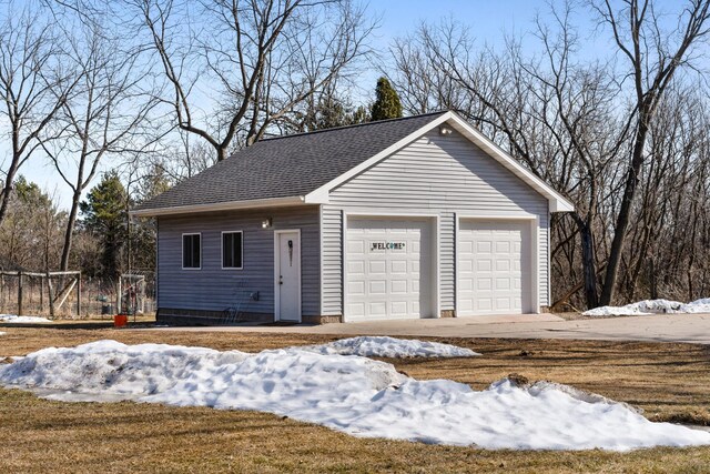 snow covered garage featuring a garage