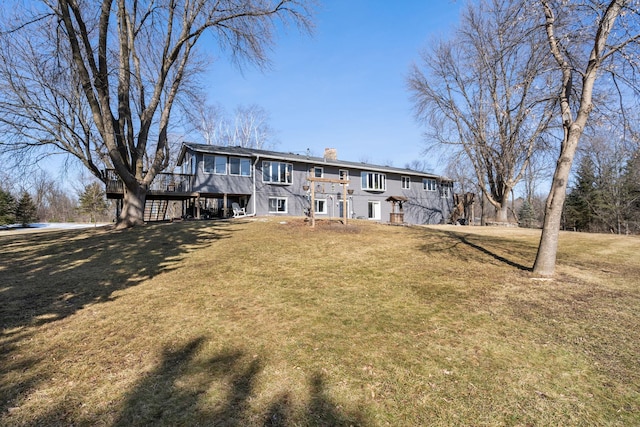 rear view of house featuring stairs, a wooden deck, a yard, and a chimney