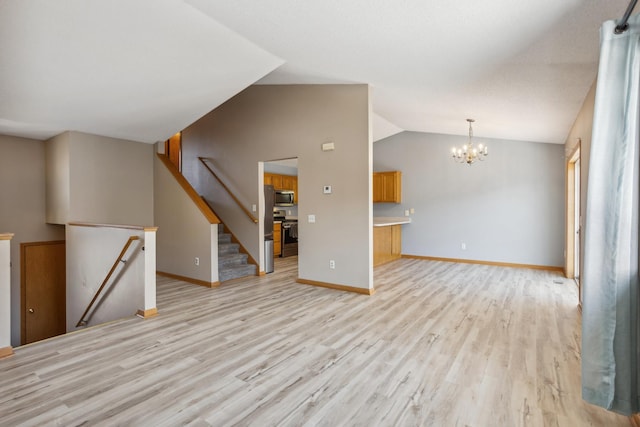 unfurnished living room with a chandelier, lofted ceiling, baseboards, and light wood-style flooring