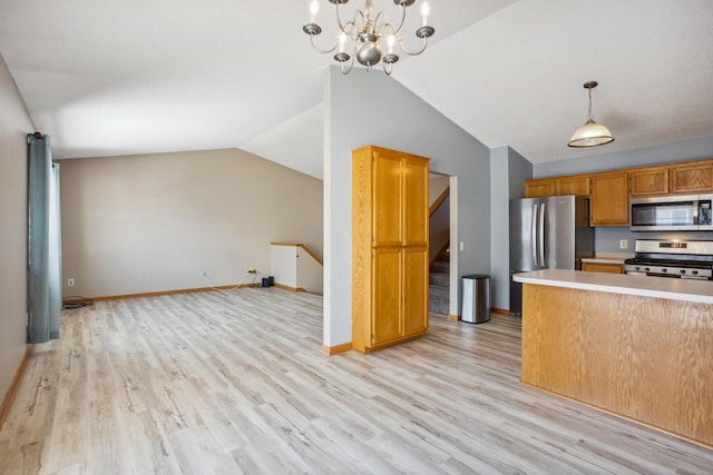 kitchen with lofted ceiling, light countertops, light wood finished floors, and appliances with stainless steel finishes