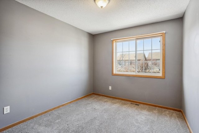 empty room with visible vents, baseboards, carpet, and a textured ceiling