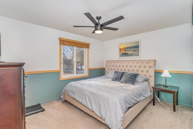 bedroom with ceiling fan, a textured ceiling, baseboards, and carpet floors