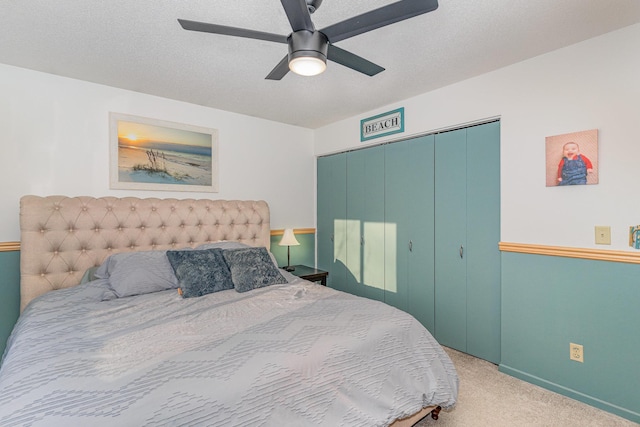 carpeted bedroom featuring a closet, a textured ceiling, and a ceiling fan