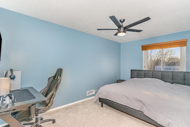 carpeted bedroom with ceiling fan, a textured ceiling, and baseboards