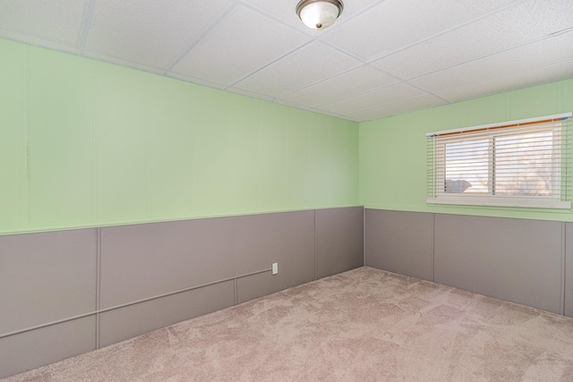 carpeted empty room with a drop ceiling