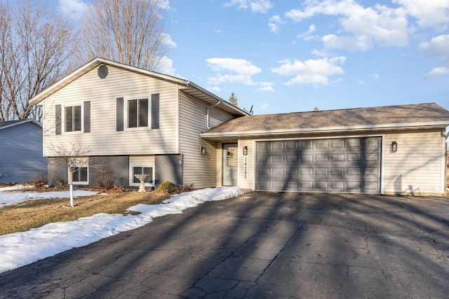 tri-level home featuring aphalt driveway and a garage