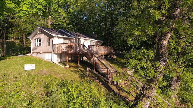 2897 Indian Mound Rd, Luck, WI 54853 - back of house featuring a deck, a lawn, stairs, and a forest view