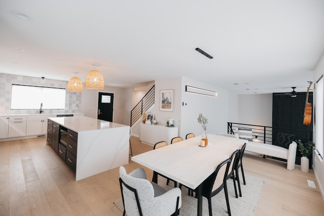 dining area with stairs and light wood-style floors