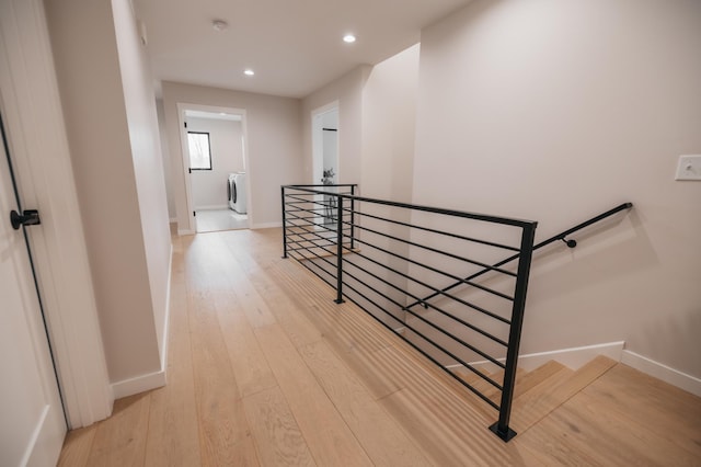 corridor with baseboards, washer / clothes dryer, recessed lighting, an upstairs landing, and light wood-type flooring