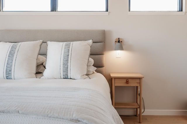 bedroom featuring wood finished floors and baseboards