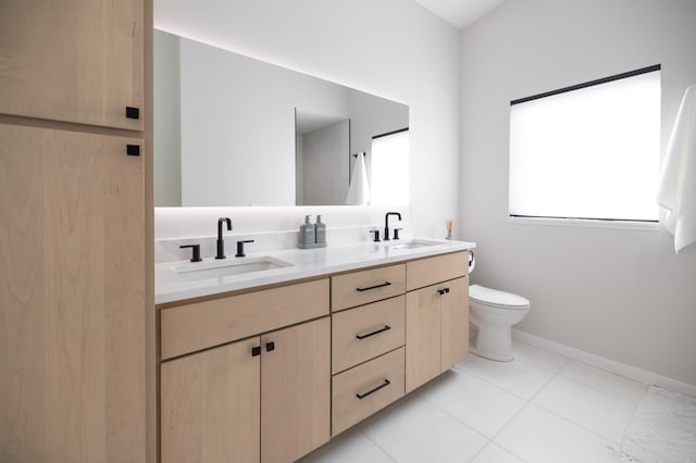 bathroom with double vanity, tile patterned flooring, toilet, and a sink