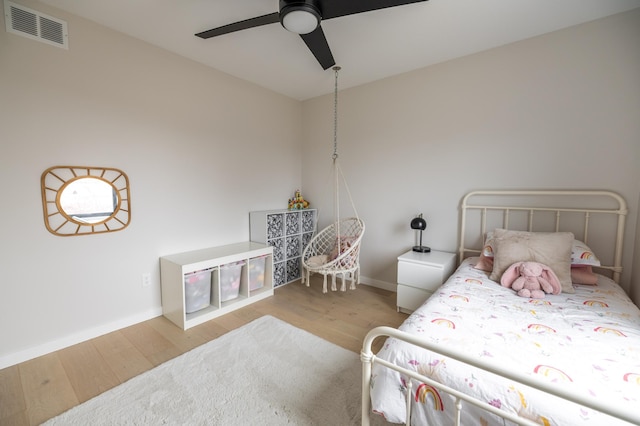 bedroom featuring ceiling fan, wood finished floors, visible vents, and baseboards