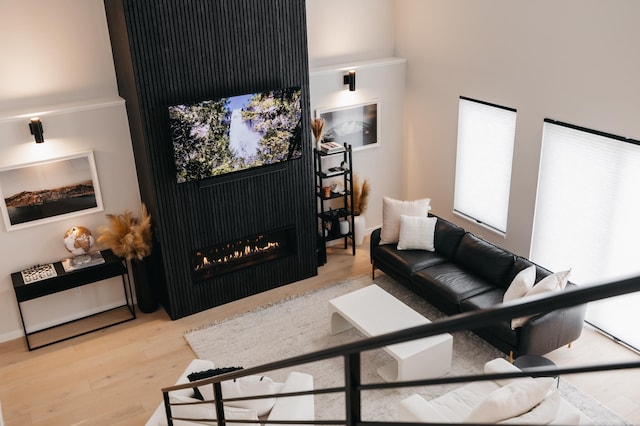 living room featuring wood finished floors and a lit fireplace