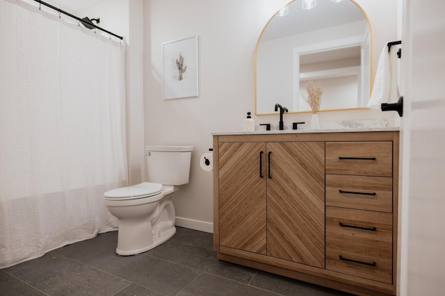 bathroom with baseboards, toilet, and vanity