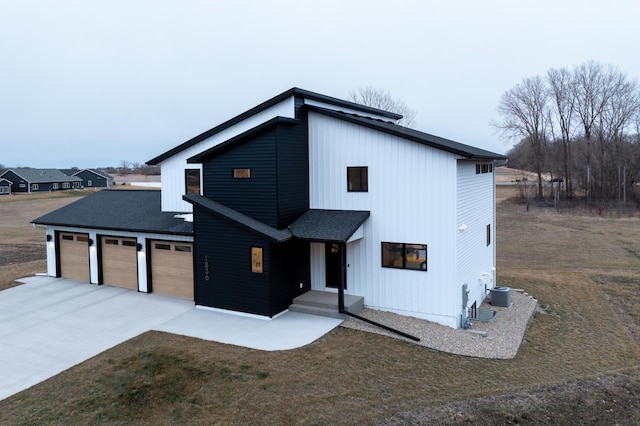 view of front facade featuring an attached garage, driveway, and roof with shingles