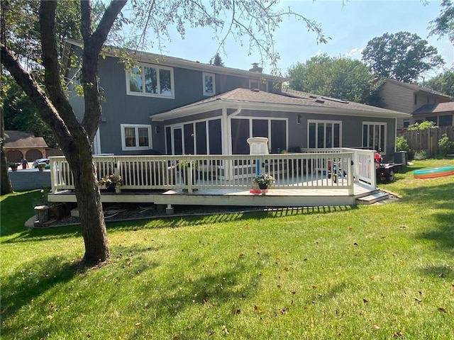 rear view of property featuring a wooden deck, a lawn, a chimney, and fence